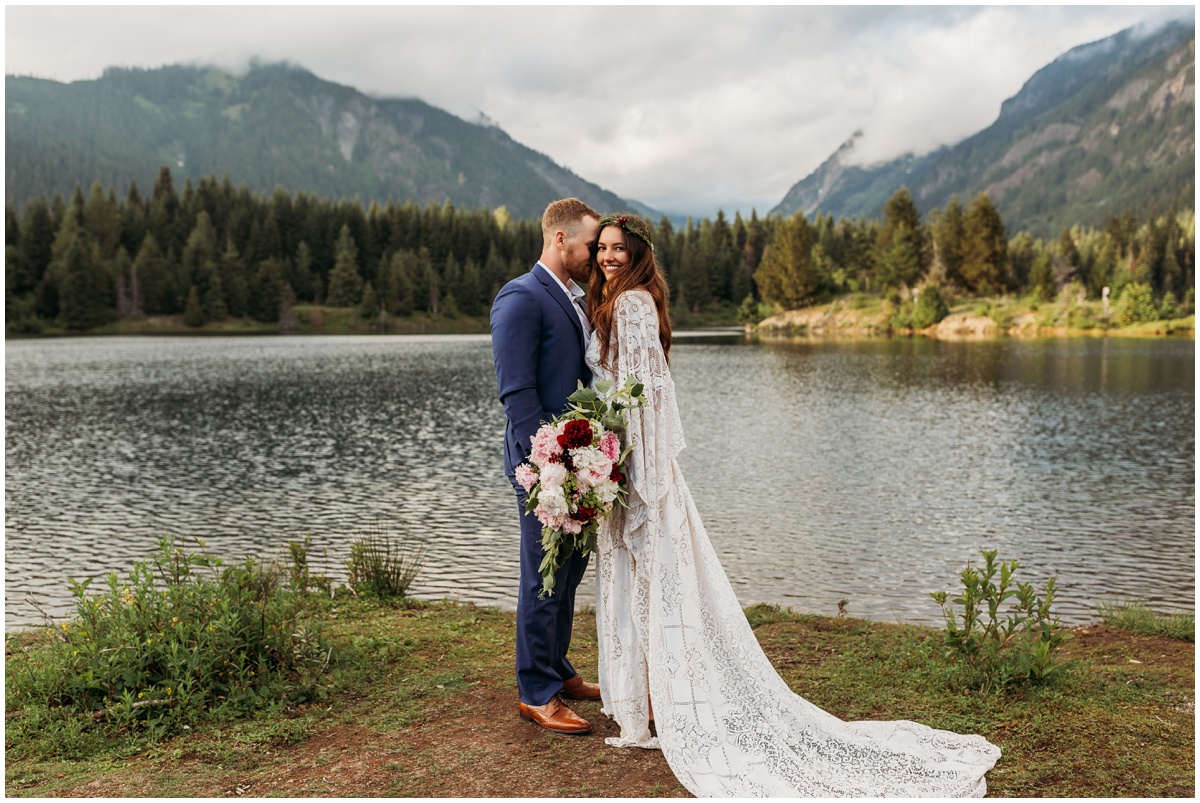 bride and groom standing by lake and mountains | Gold Creek Pond Washington Elopement Photographer