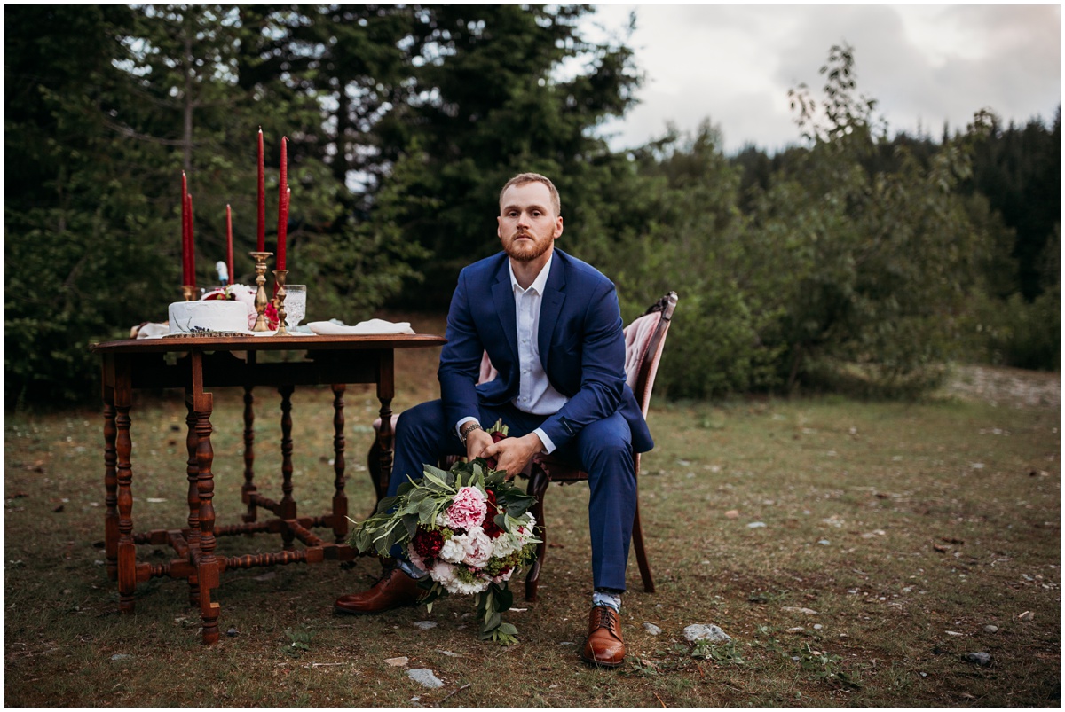 groom holds bridal bouquet at table | Gold Creek Pond Washington Elopement Photographer