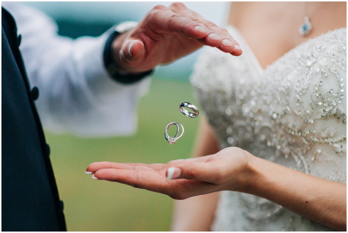 groom dropping wedding rings into brides hand | Hidden Meadows Wedding Snohomish Washington