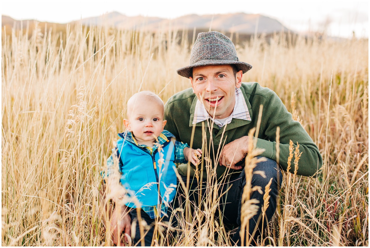 father smiling with son in field