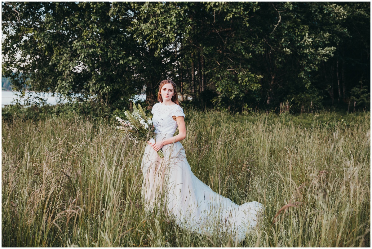 bride poses with flowers in grass