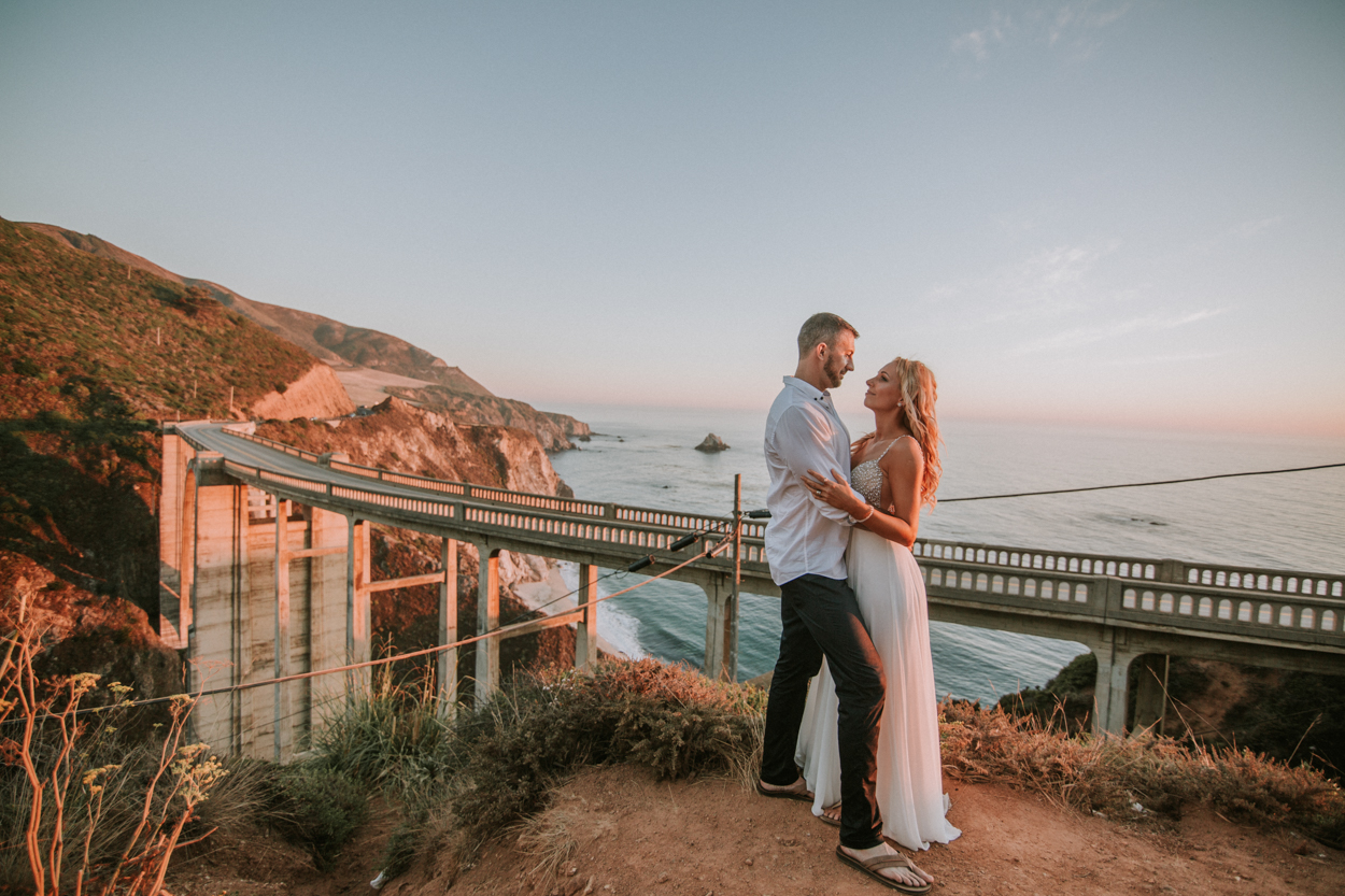 couple hold each other at bixby bridge in big sur
