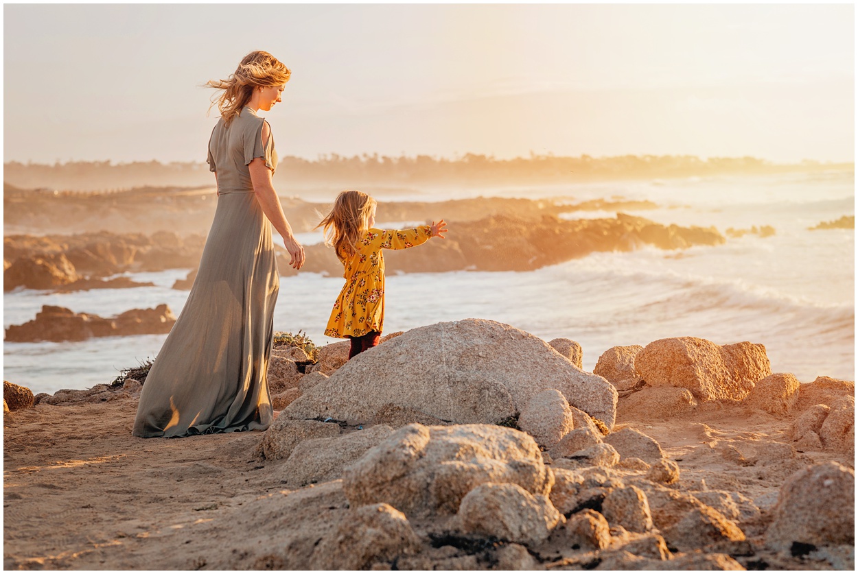 mother and daughter standing by the ocean