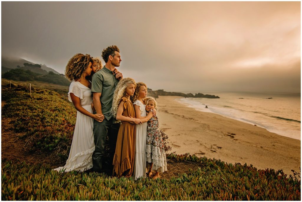 curly hair family looking at ocean at garapata beach