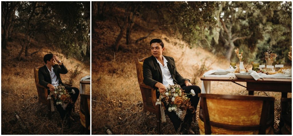 groom sitting at wedding table with bouquet