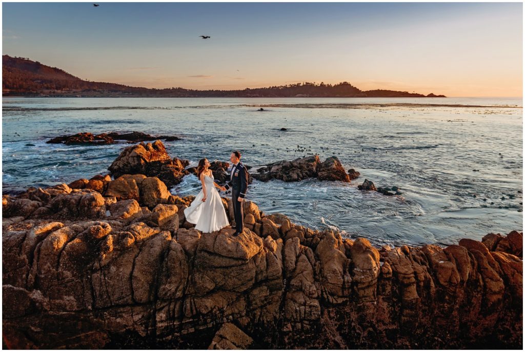 bride and groom holding hand by the ocean