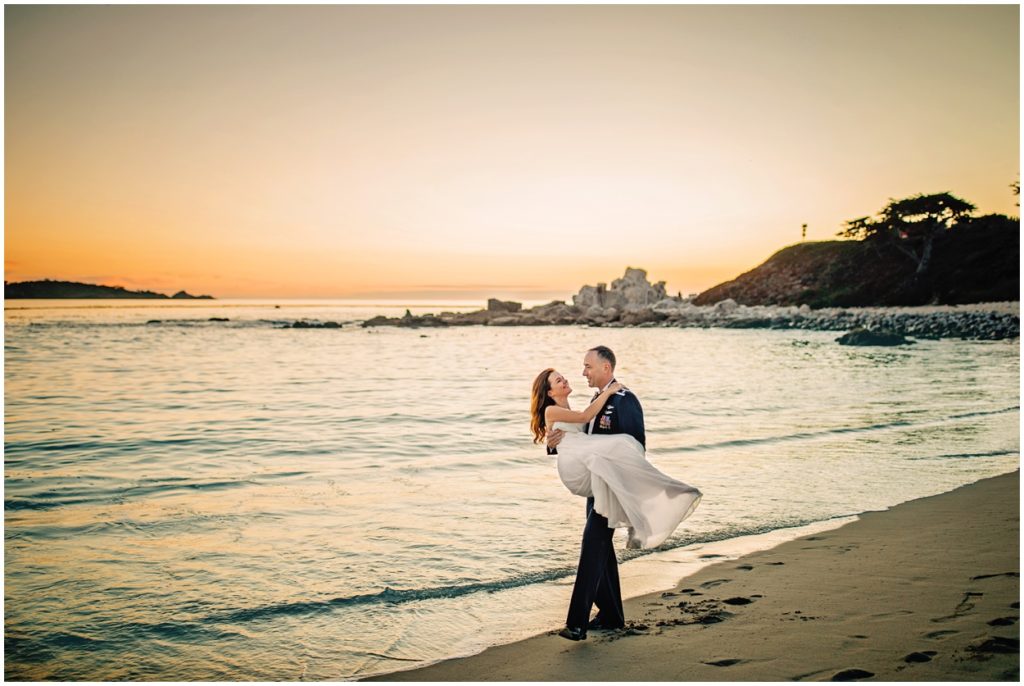 groom holding bride by the ocean